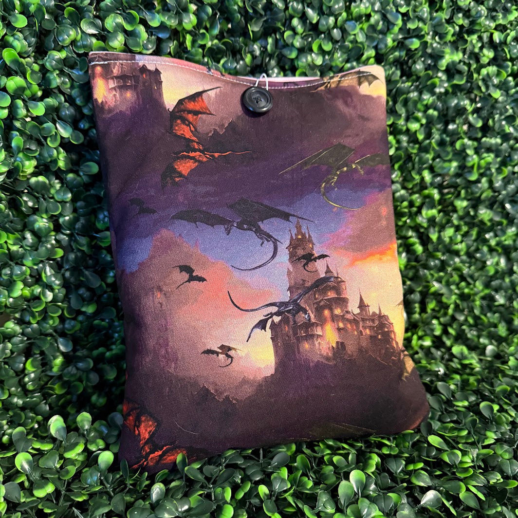 Decorative pillow with dragon and castle design on a green textured surface