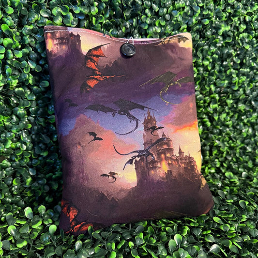 Decorative pillow with dragon and castle design on a green textured surface